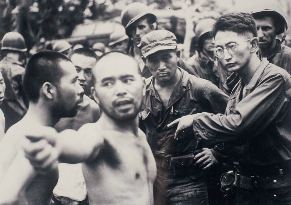 Harry (right), an officer in the U.S. Army, interrogates a Japanese POW in Aitape, New Guinea, in April 1944.